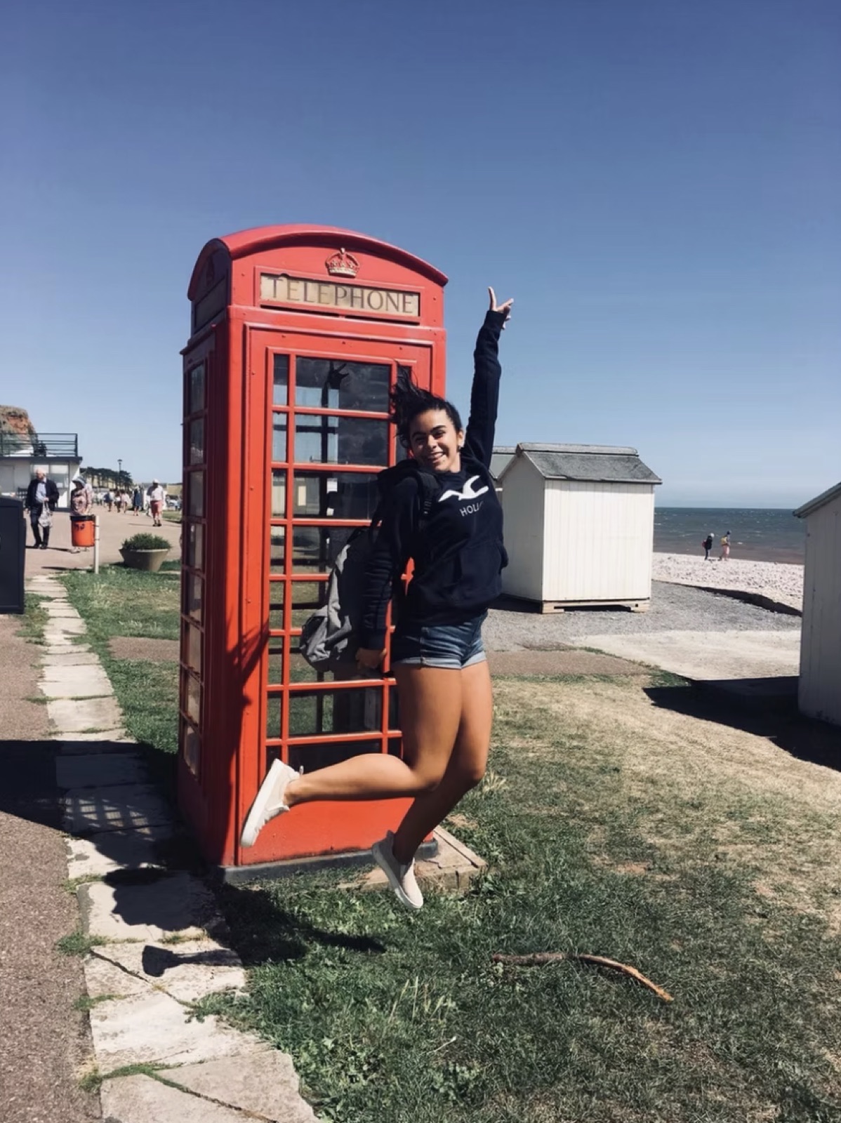 Alumna junto a una cabina telefónica roja en Inglaterra